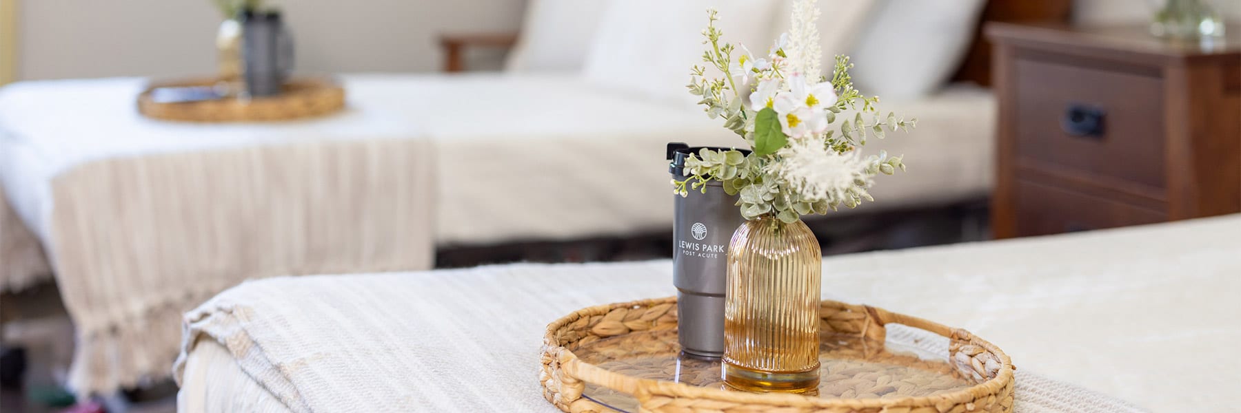 flowers and water cup on a tray on a bed at Lewis Park Post Acute